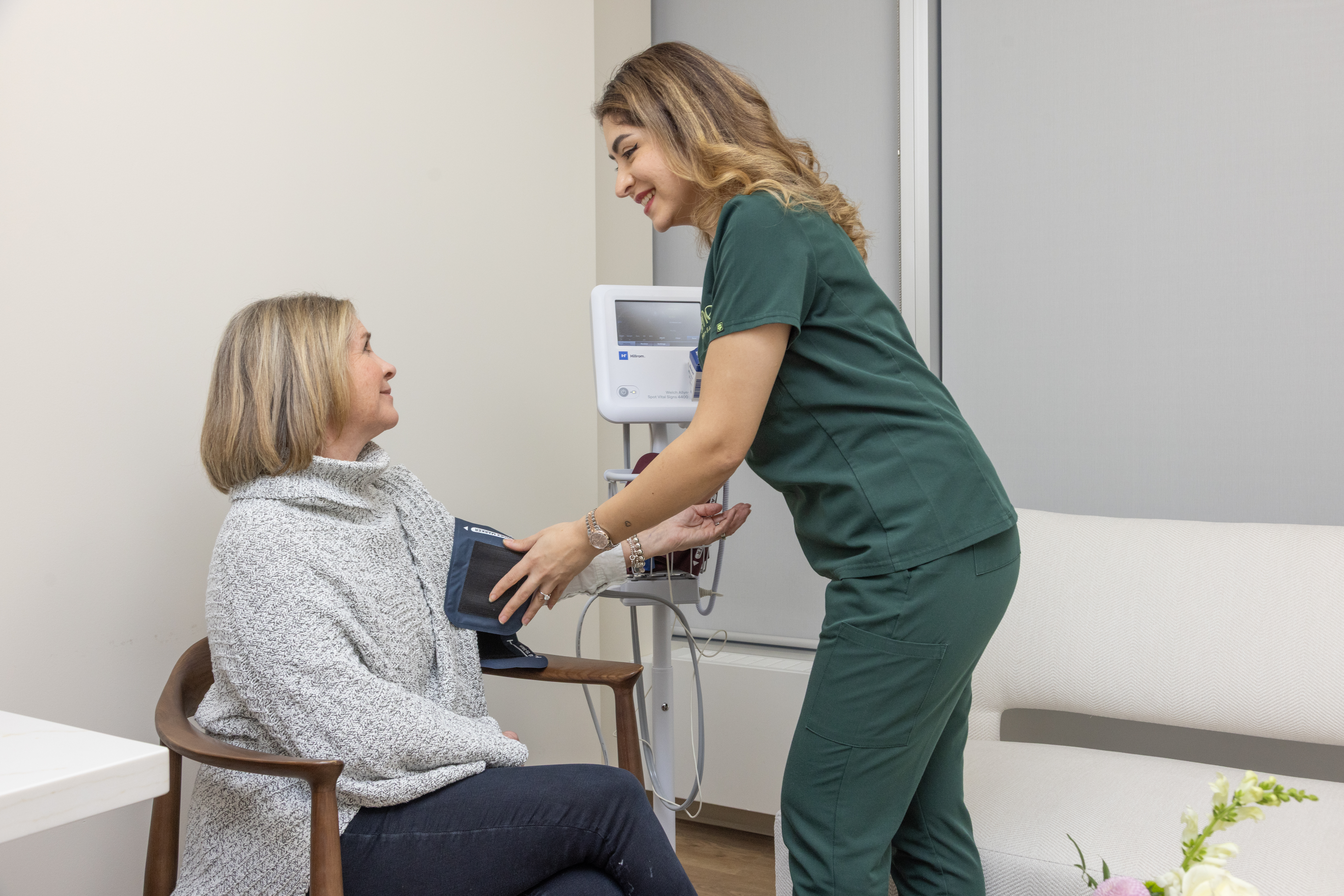 Nurse taking woman's blood pressure
